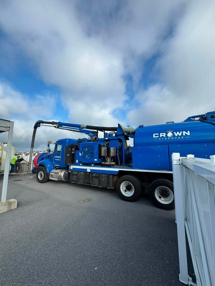 Side profile of the Crown Hydrovac vacuum truck showing the CROWN HYDROVAC decal on the debris tank