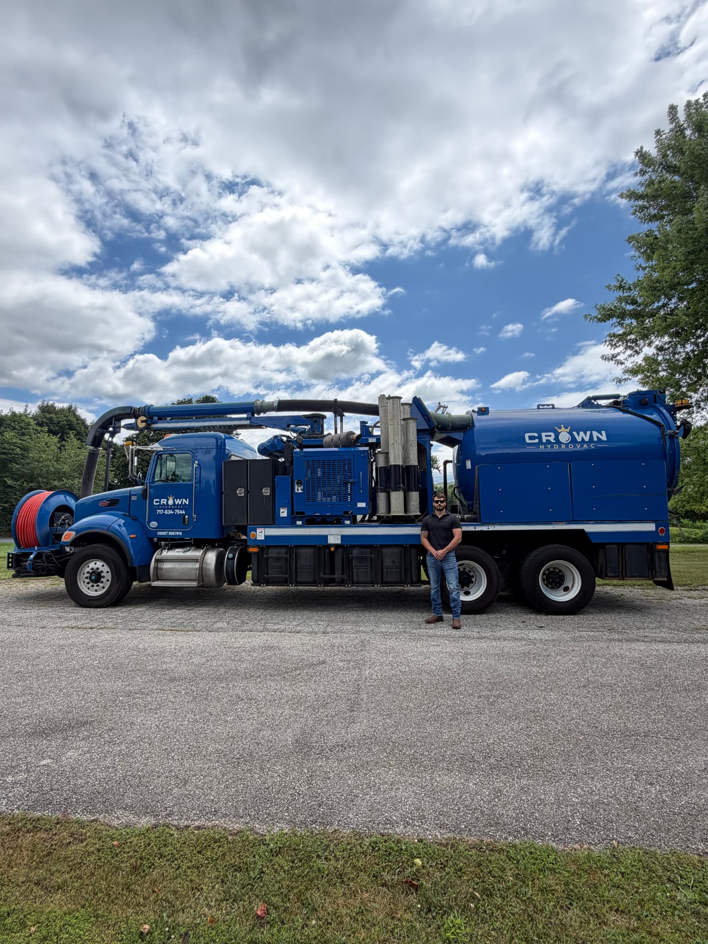 Crown Hydrovac crew member standing beside the full vacuum truck